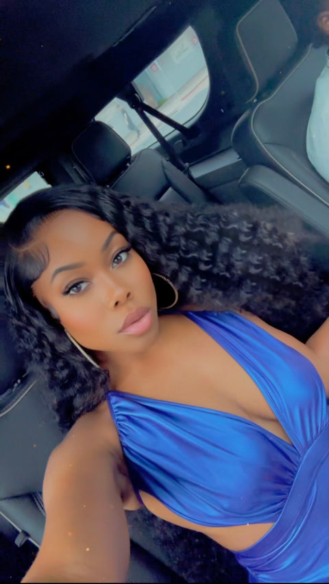 Woman in a blue top sitting inside a vehicle