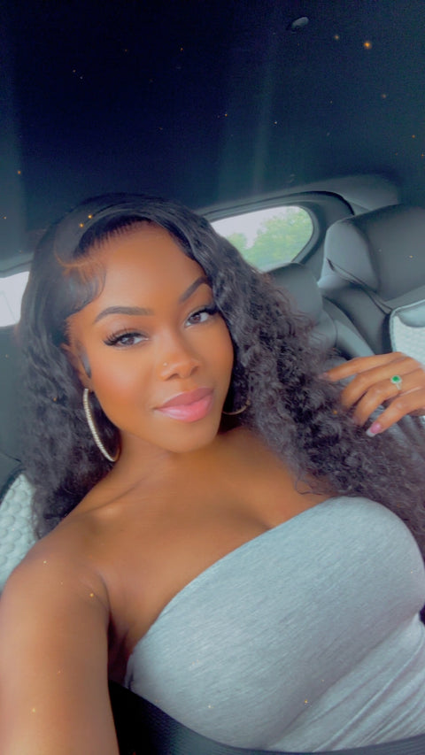 Woman sitting in a car wearing a strapless light blue top.