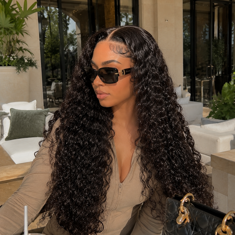 Woman with long curly hair wearing sunglasses in an outdoor setting