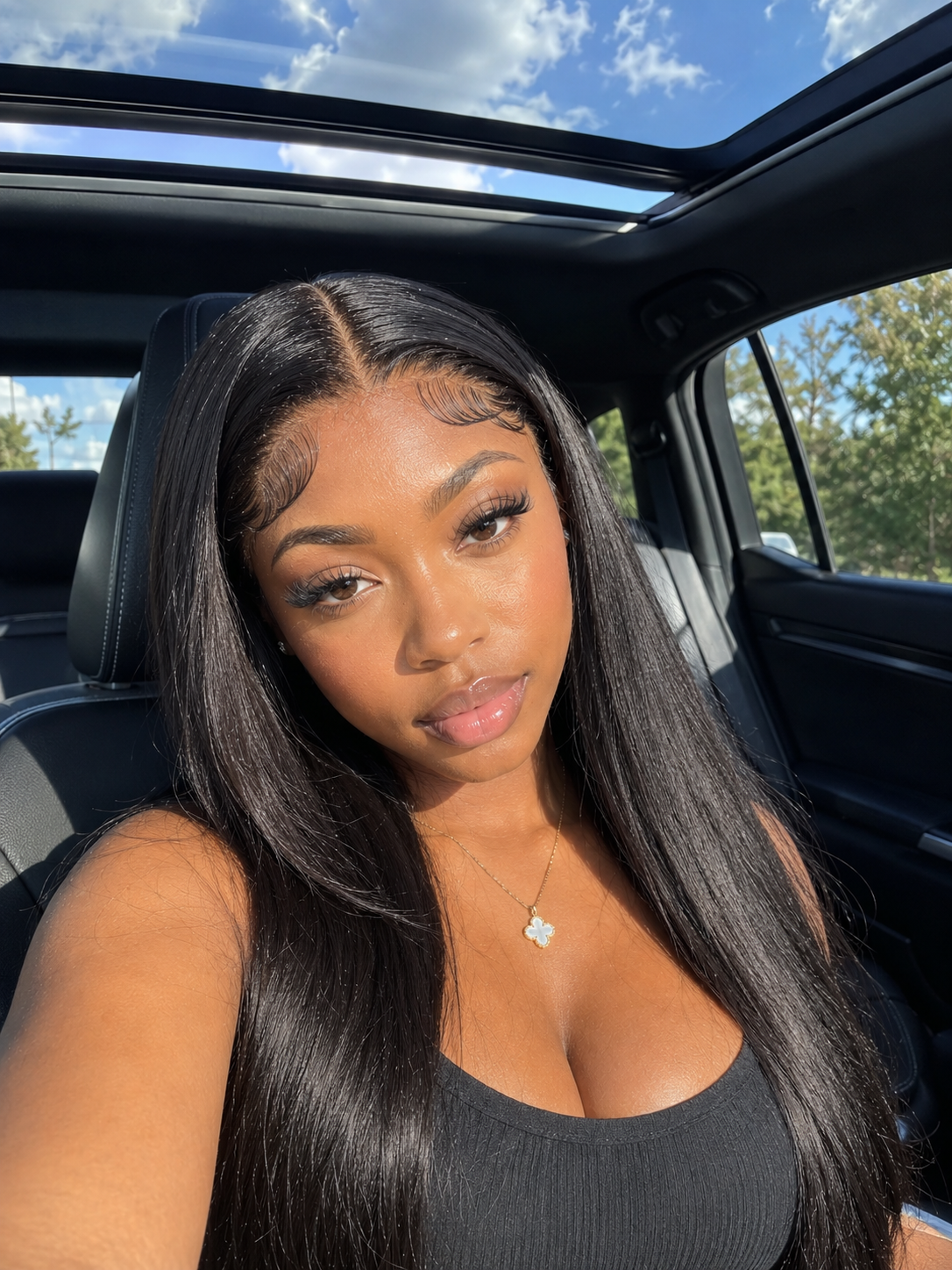 Girl sitting in a car taking a selfie bright summer day